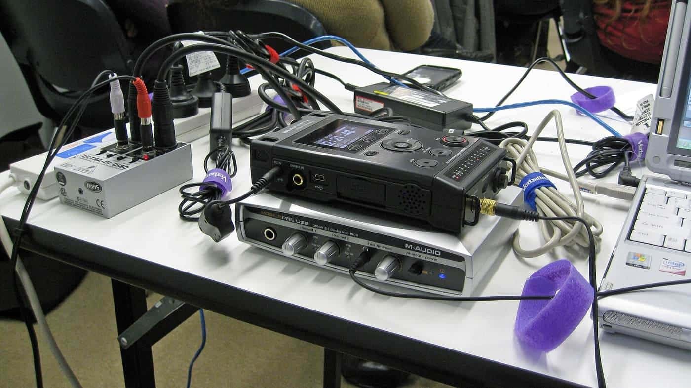 A laptop, camera and microphone set up for a webinar and podcast